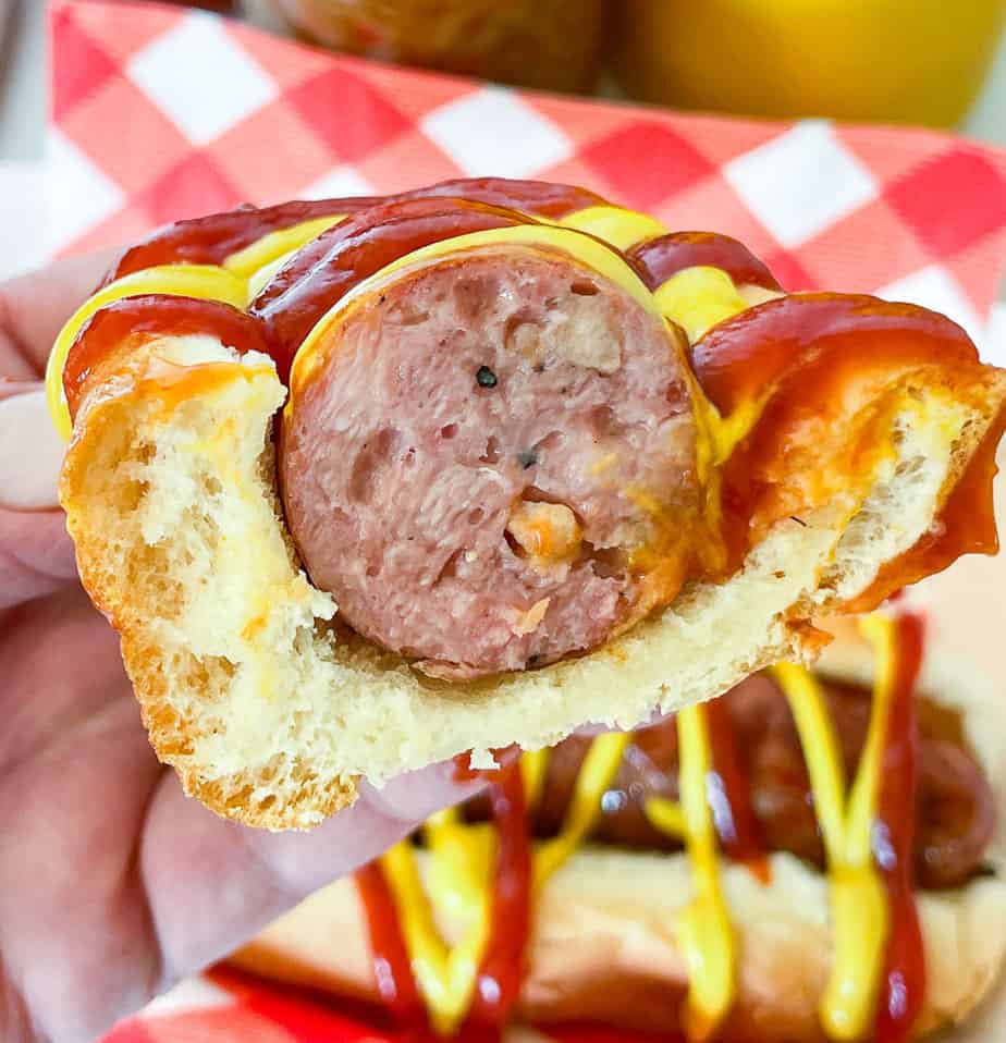 Sliced sausage in a bun with ketchup and mustard.