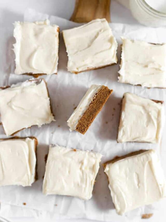 Gingerbread bars with cream cheese frosting on a baking sheet.