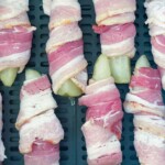 Air Fryer basket full of pickle spears wrapped in bacon.