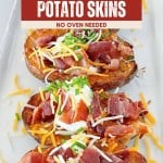 Four air fryer potato skins on a white plate topped with cheese, bacon, and green onions. Text above reads, “Crispy, Cheesy, Easy Air Fryer Potato Skins - No Oven Needed.”.