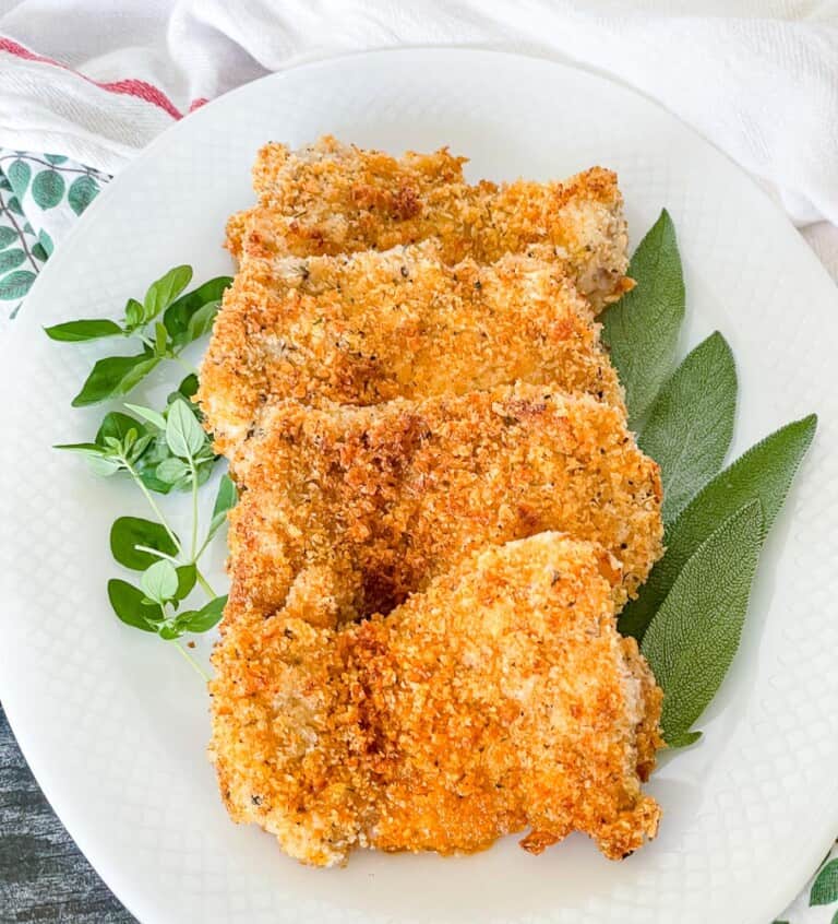 Plate with crispy chicken and fresh herbs.