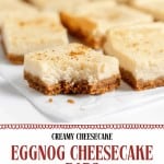 Several Eggnog Cheesecake Squares with a graham cracker crust are arranged on a white surface. The image promotes a festive holiday dessert recipe.