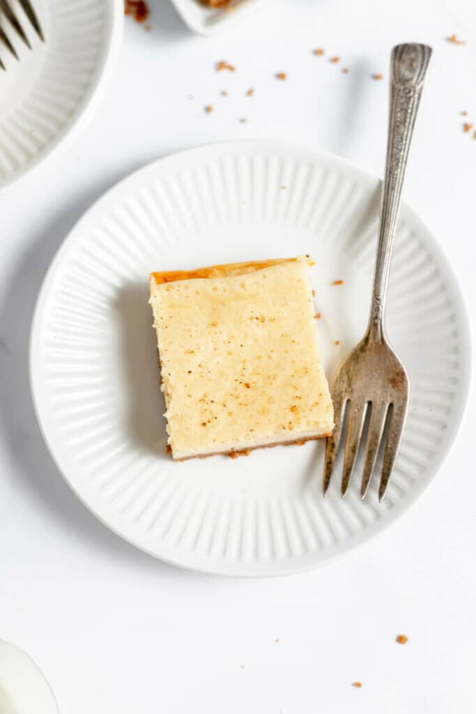A single perfect piece of eggnog cheesecake on a place. 