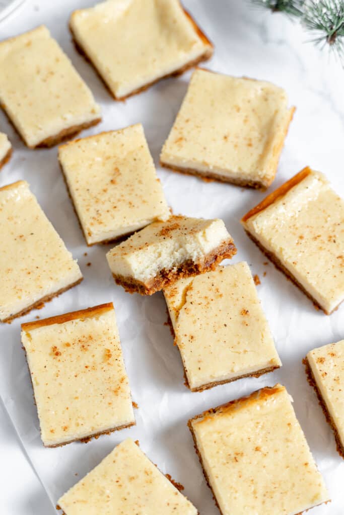 Eggnog cheesecake squares on parchment paper. 