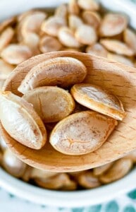 Air Fryer pumpkin seeds in a wooden spoon.