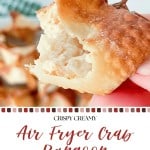 A hand holds a bitten Crab Rangoon, showcasing its creamy filling fresh from the air fryer. More crispy crab rangoons are blurred in the background. Text overlay reads: “Air Fryer Crab Rangoon Party Bites.”.