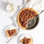 Classic Southern Bourbon Pecan Pie served on two plates with whipped cream in a bowl.