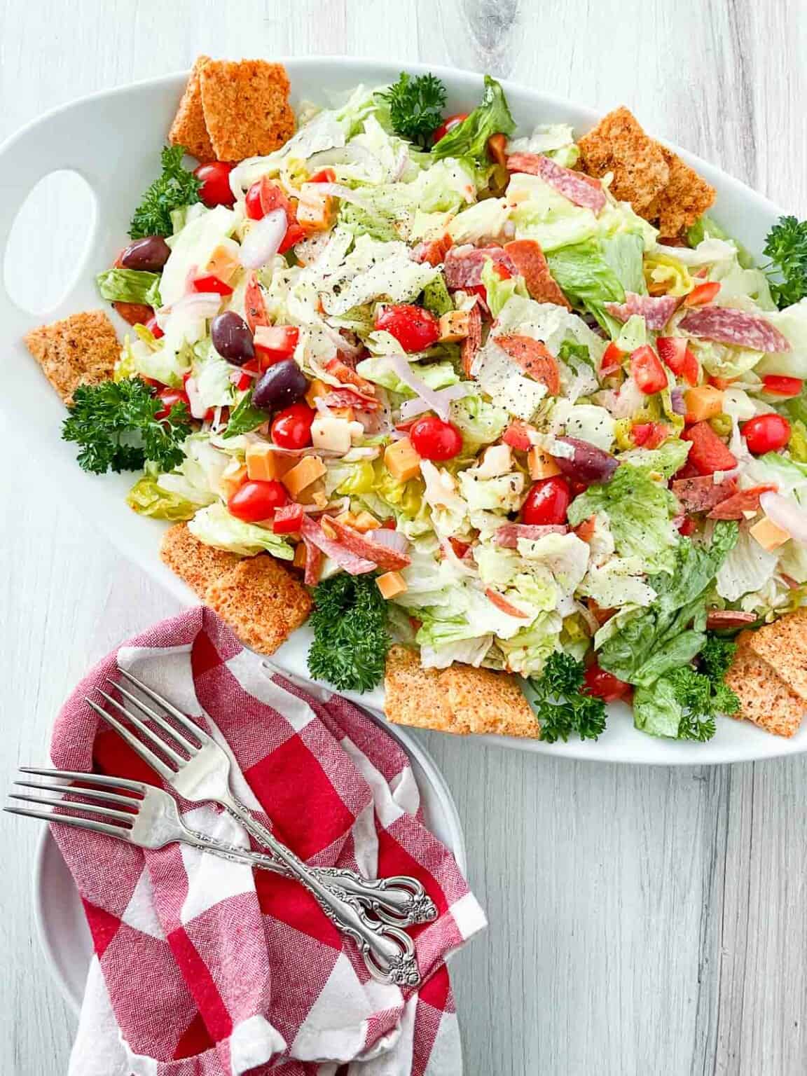 A platter of salad with croutons.