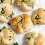 Finished garlic knots covered in herbs, butter and cheese.