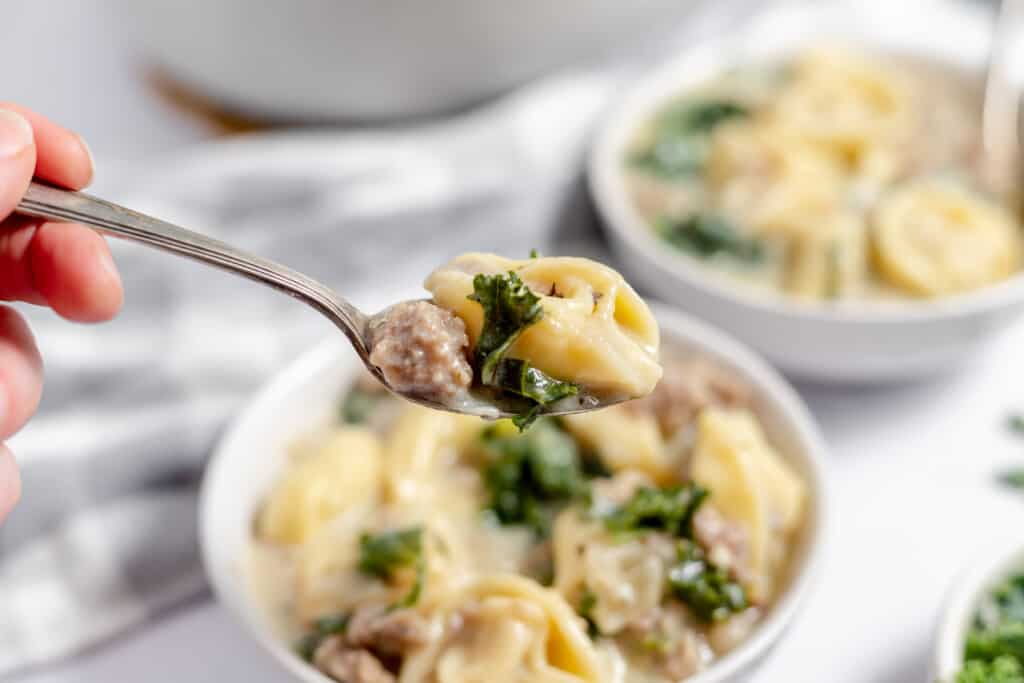 A spoonful of sausage tortellini soup. 
