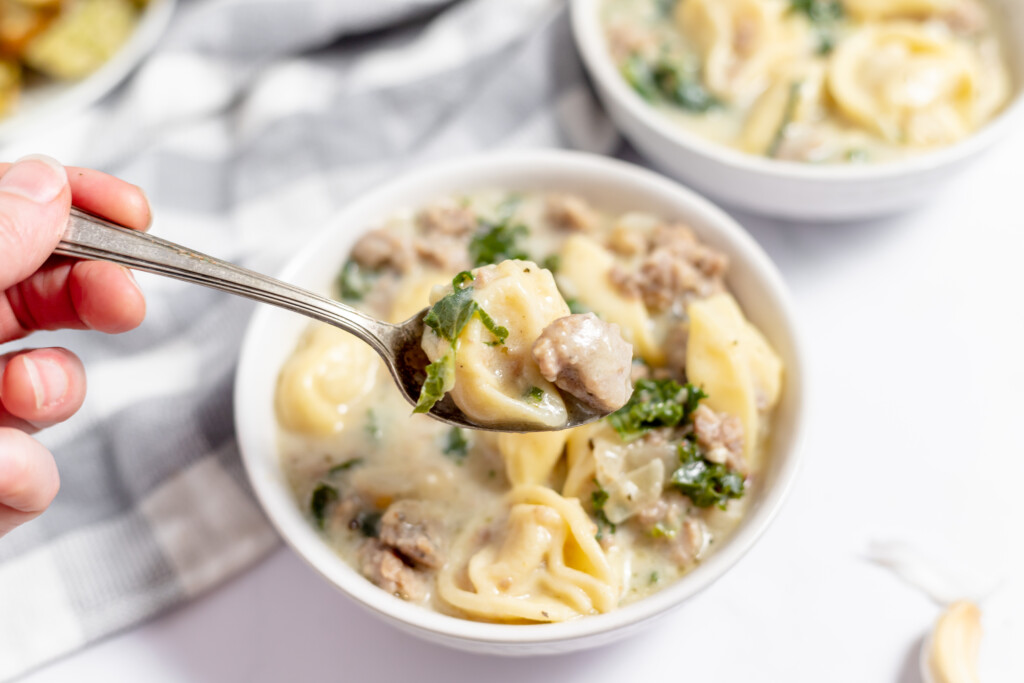 A spoonful of sausage tortellini soup.