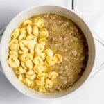 Tortellini added to soup in dutch oven.