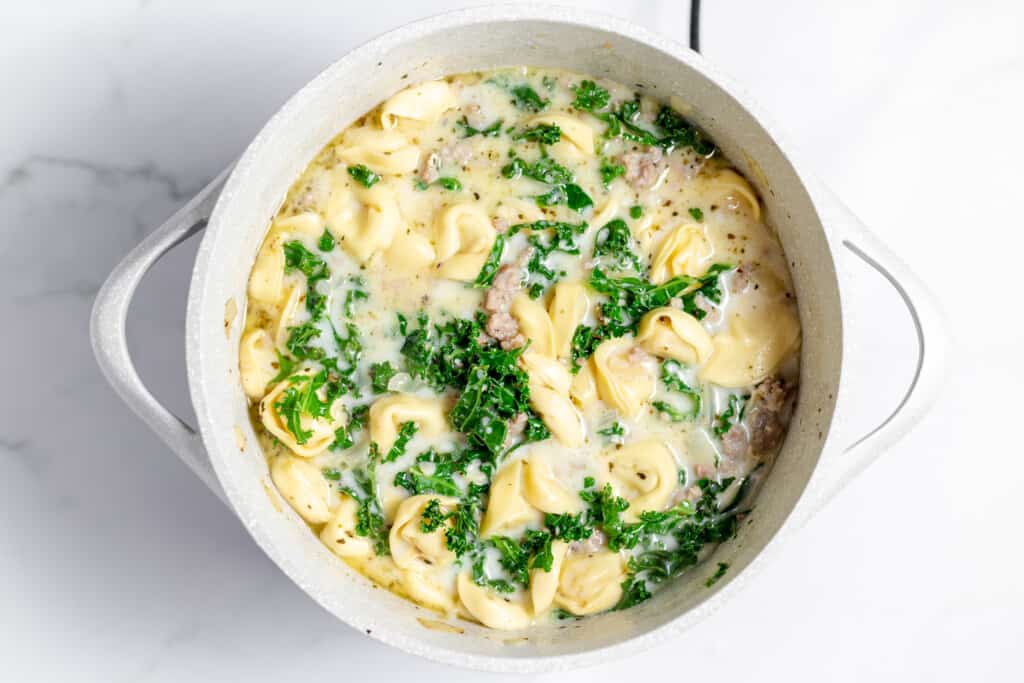 A pot full of creamy sausage tortellini soup.