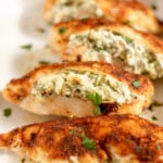Spinach stuffing in a chicken breast in a baking dish.