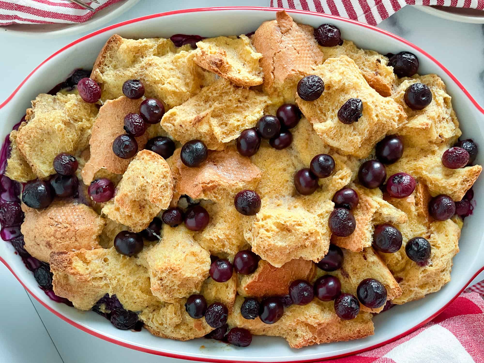 Syrup being poured over blueberry casserole.