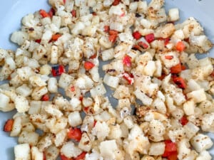 Onions, potatoes, and peppers cooked in a pan.