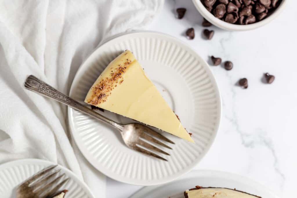 Slice of brownie cheesecake with chocolate crumb garnish.