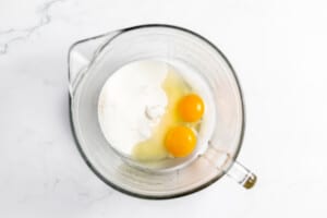 Eggs and sugar in a mixing bowl.