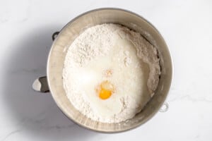 Adding milk and eggs to the dry ingredients in a mixing bowl.