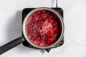 Cranberries in a saucepan boiling until they split.