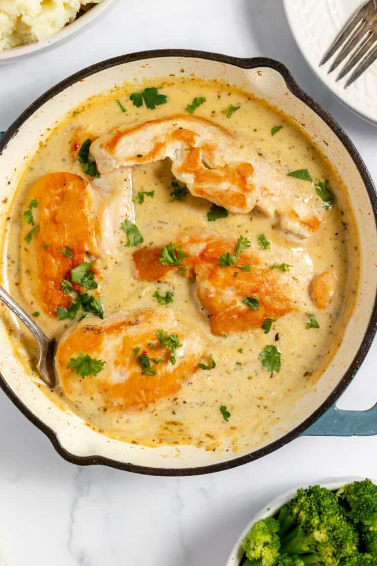 Creamy ranch chicken on a skillet garnished with parsley.