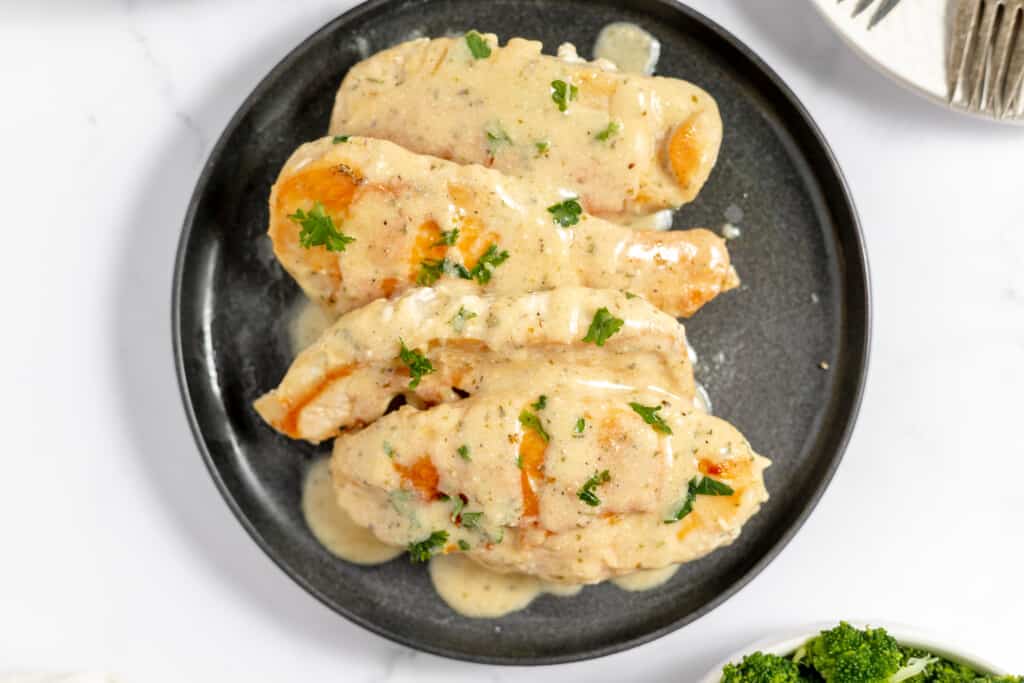 Creamy Ranch Chicken breasts with gravy on a plate.