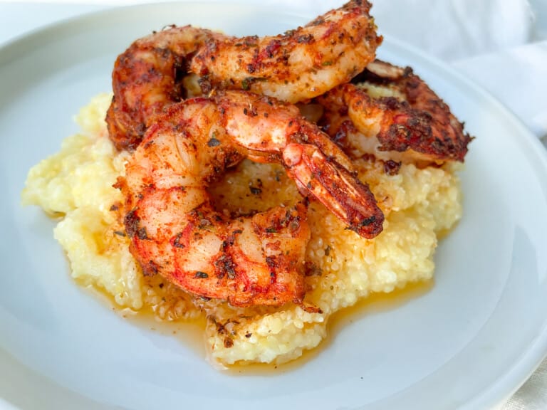 Air Fryer Blackened Shrimp on polenta with butter melted around it.
