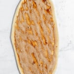 Cinnamon and sugar sprinkled on top of bread dough.