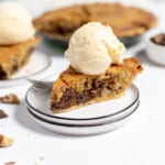 A slice of pie in the center of the photo with more pie in the background.