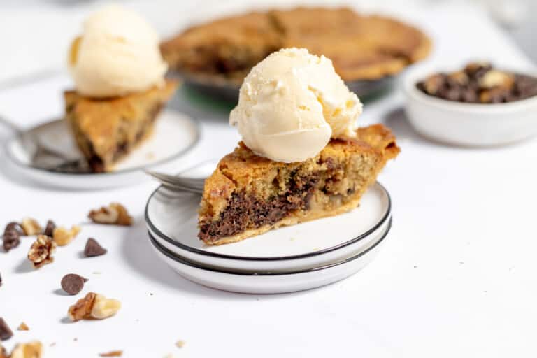 A slice of pie in the center of the photo with more pie in the background.