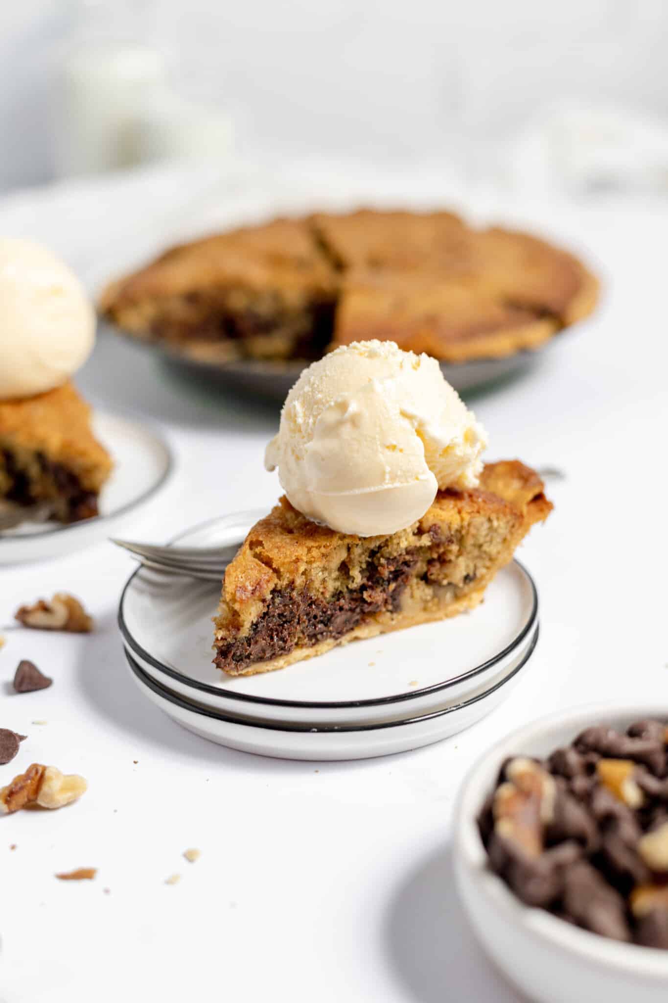 A slice of pie in the center of the photo with more pie in the background.