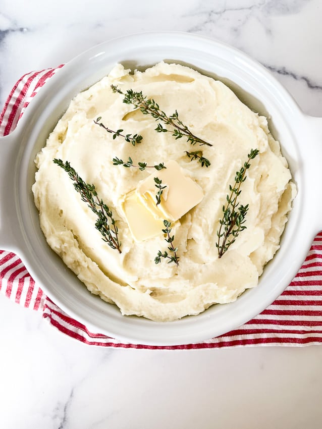 Buttery mashed potatoes with sprigs of thyme.
