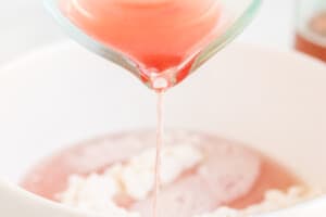 Drizzling champagne into cake batter.