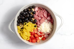 Ingredients on top of cooked tortellini for a salad.