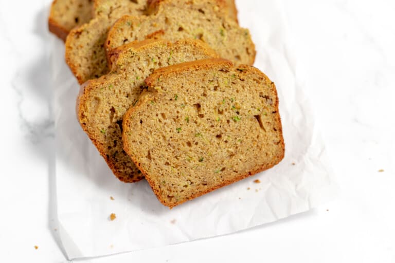 Slices of zucchini banana bread on a parchment paper.