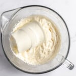 Ricotta cheese and whipped cream in a mixing bowl.