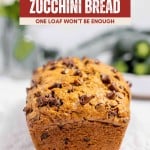 A loaf of chocolate chip zucchini bread sits on a white surface with a blurred background. The text above reads: "Chocolate Chip Zucchini Bread—one irresistible loaf won’t be enough.