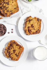 Slices of chocolate chip banana bread on white plates.