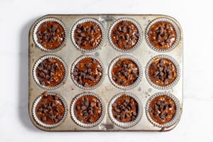 Chocolate chips on top of chocolate muffin batter before baking.