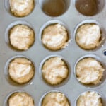 Lemon muffin batter in a muffin pan.