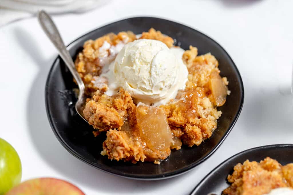 Apple crisp with ice cream on a plate.