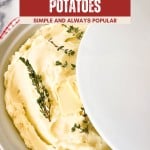 A bowl of fluffy whipped potatoes topped with butter and thyme sprigs, partially covered by a white lid, rests atop a red and white striped towel.