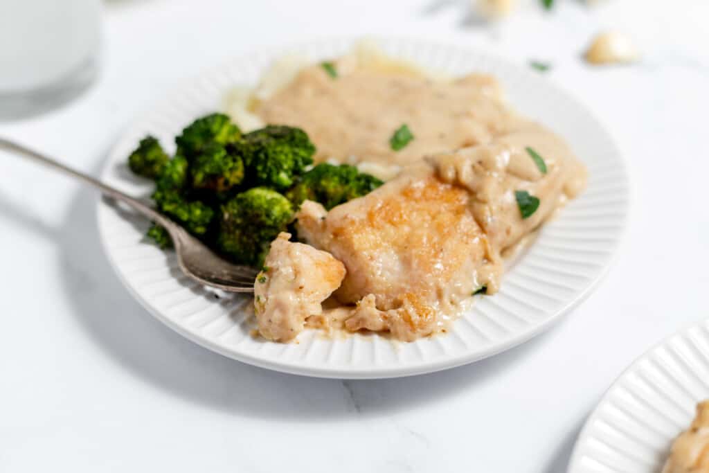 Creamy garlic chicken with a bite served with mashed potato and broccoli.