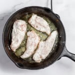 Chicken fried in a skillet.