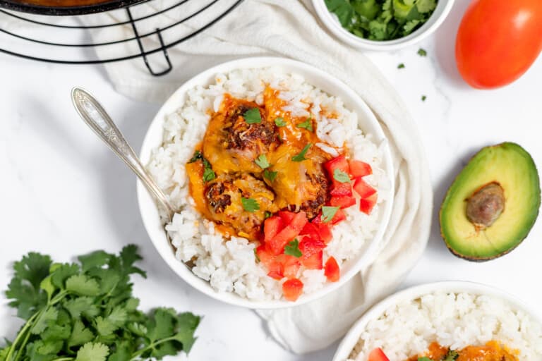 A bowl of enchilada meatballs with tomatoes and avocado.
