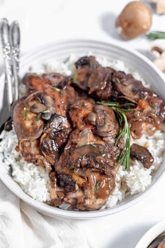 Chicken breasts with mushrooms and rice in a white bowl, served in a chicken marsala sauce.