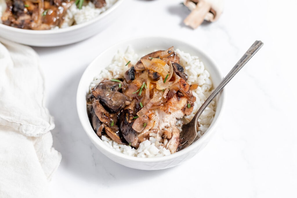 Two bowls of rice with chicken marsala.