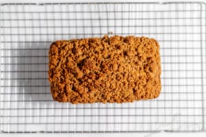 A pumpkin bread sitting on a cooling rack.