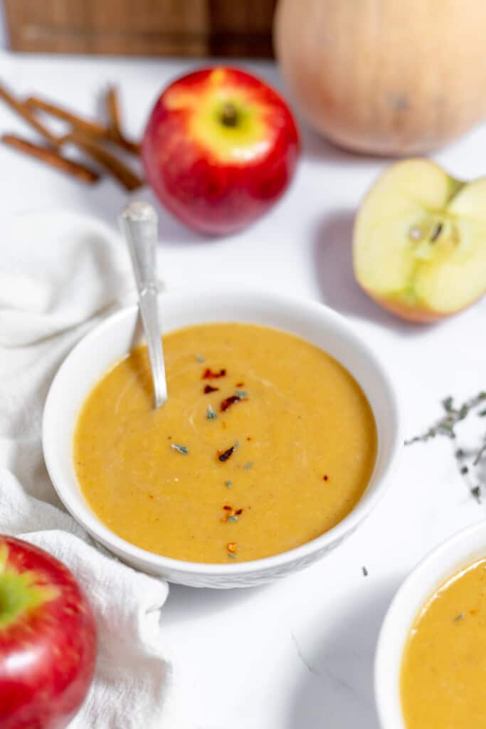 Two bowls of soup with apples and spices.