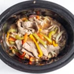 A crock pot filled with meat and vegetables.